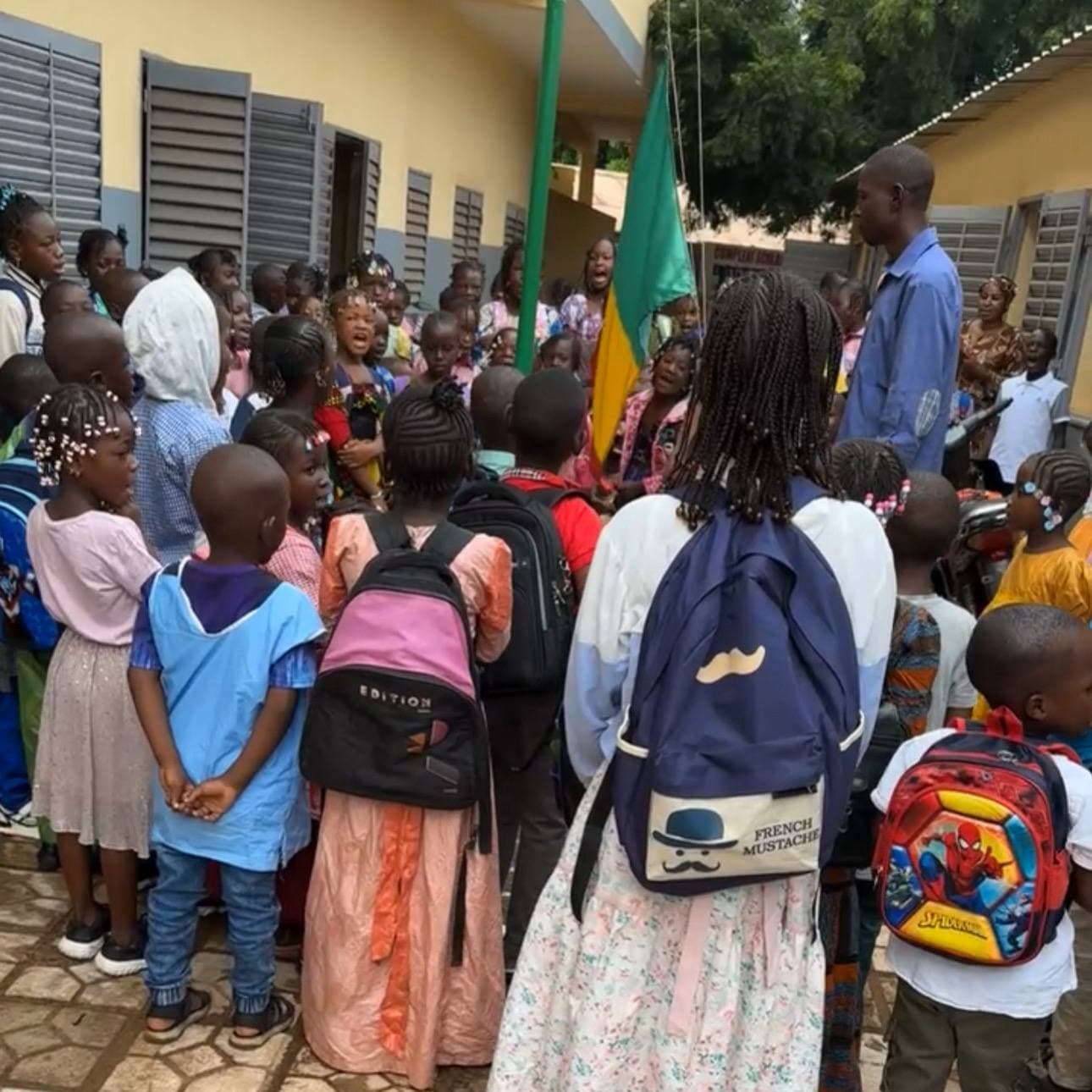 Enfants et adultes rassemblés devant le bâtiment de Daga Keita