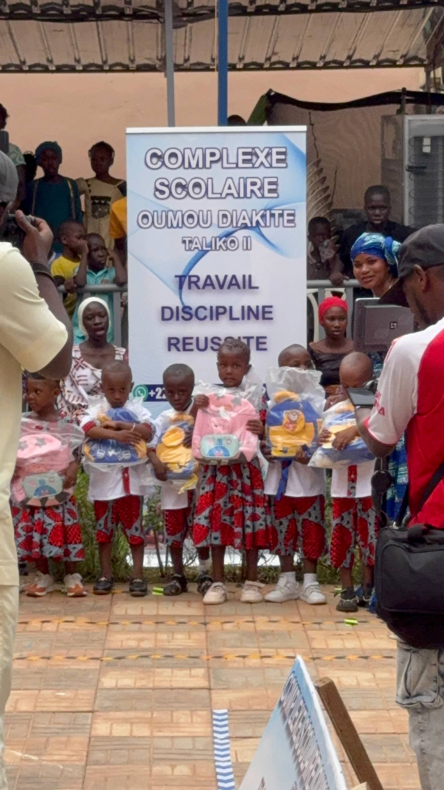 Jeunes enfants, trophées et bannière d’Oumou Diakité lors d’une cérémonie